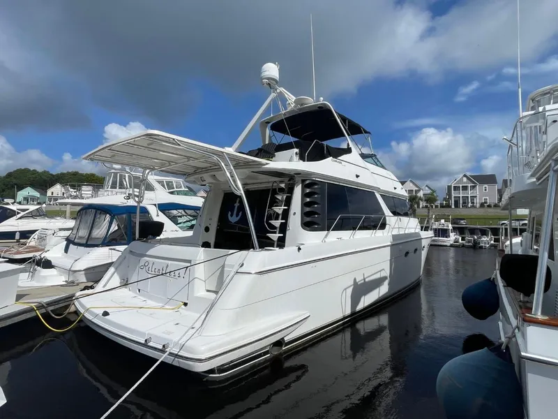 Slide: The Image of 1998 Carver 530 Voyager Pilothouse yacht docked at marina under blue sky. - 2