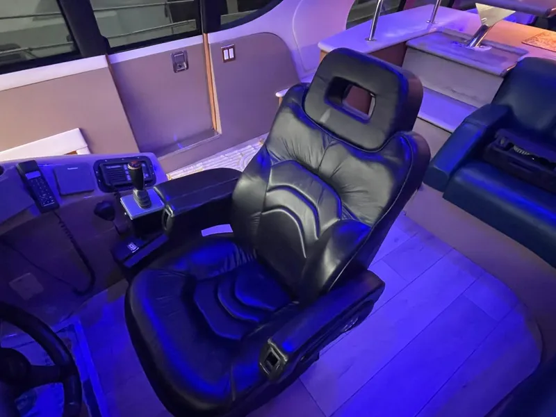 Slide: The Image of Luxurious leather captain's chair in 1998 Carver 530 Voyager Pilothouse, illuminated by blue lighting. - 46
