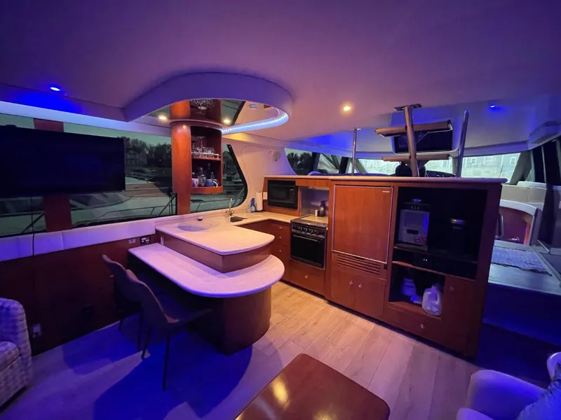 Slide: The Image of Luxurious interior of 1998 Carver 530 Voyager Pilothouse with modern kitchen and ambient lighting. - 27