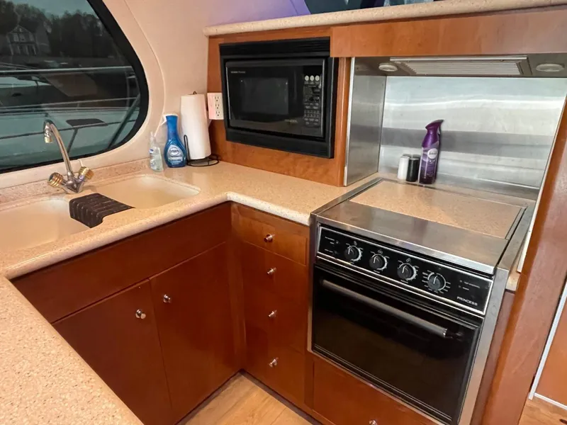 Slide: The Image of 1998 Carver 530 Voyager Pilothouse kitchen with stove, microwave, and sink. - 30