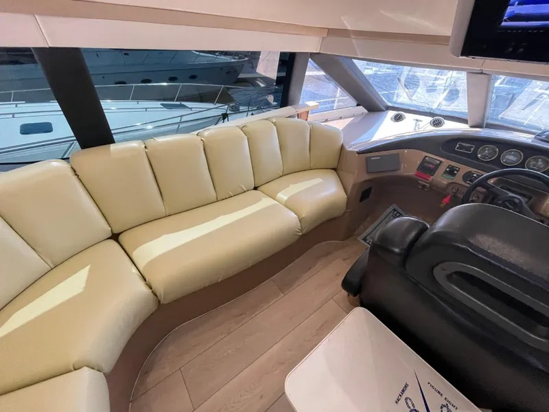 Slide: The Image of Interior of 1998 Carver 530 Voyager Pilothouse with beige seating and helm controls. - 48