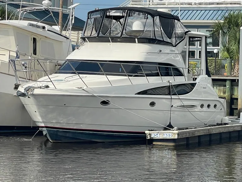 Slide: The Image of 2004 Meridian 459 Motoryacht docked at marina, featuring sleek design and spacious upper deck. - 0