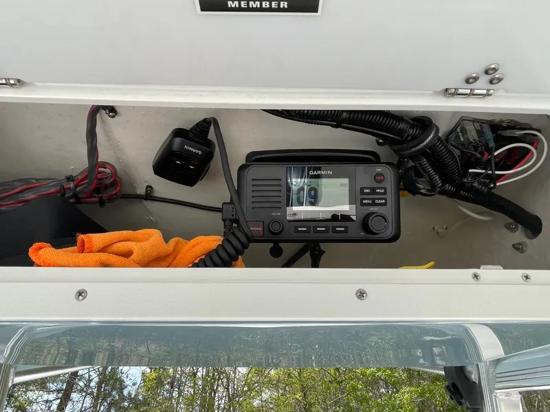 Slide: The Image of Radio equipment inside a 2022 Sea Hunt 234 Ultra boat compartment. - 16