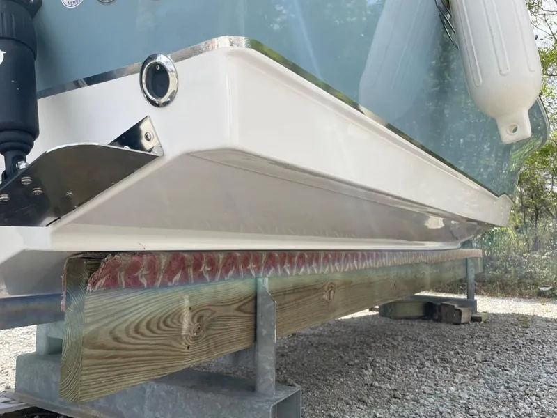 Slide: The Image of 2022 Sea Hunt 234 Ultra boat hull on wooden support, outdoor setting. - 42