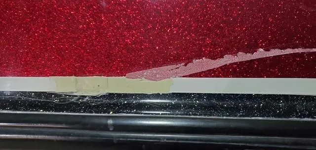 Slide: The Image of Close-up of 2001 Bass Tracker TARGA 1900 boat with red and black paint damage. - 6