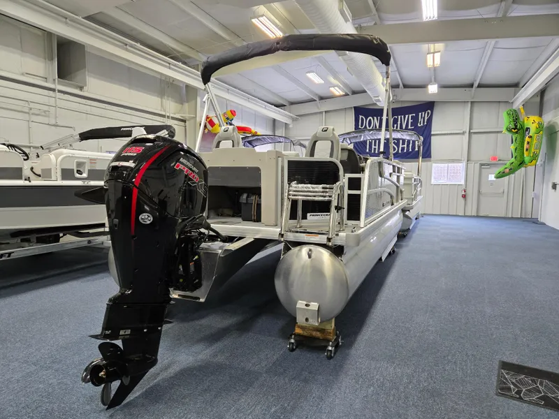 Slide: The Image of 2025 Princecraft Sportfisher 21-2RS pontoon boat in showroom, featuring powerful outboard motor. - 3