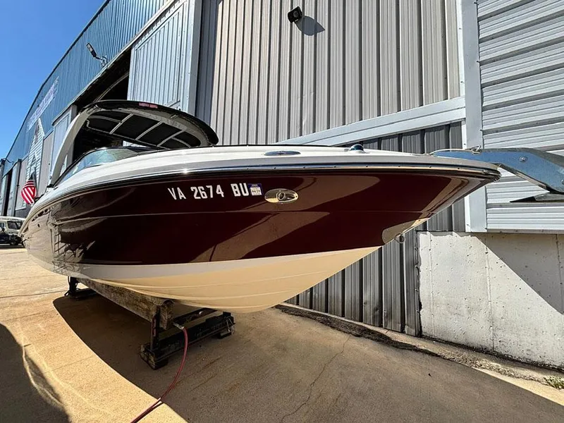 Slide: The Image of 2013 Sea Ray 250 SLX boat docked near a metal building. - 0