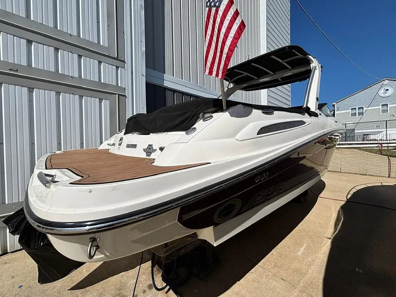 Slide: The Image of 2013 Sea Ray 250 SLX boat docked, American flag, sunny day, modern design. - 1