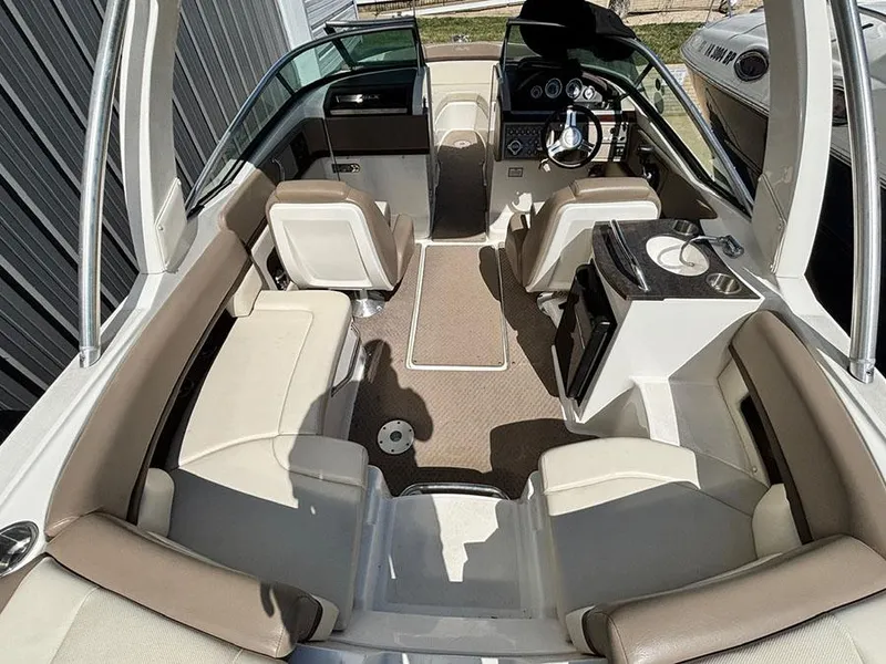 Slide: The Image of 2013 Sea Ray 250 SLX boat interior with beige seating and modern dashboard. - 11