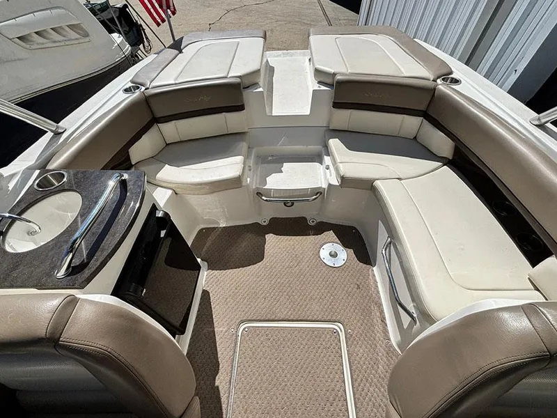 Slide: The Image of 2013 Sea Ray 250 SLX boat interior with beige seating and a small sink area. - 16