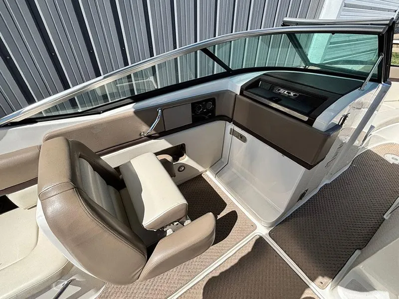 Slide: The Image of 2013 Sea Ray 250 SLX boat interior with brown seating and dashboard. - 19