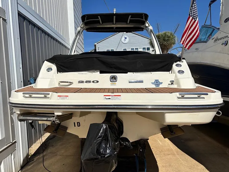 Slide: The Image of 2013 Sea Ray 250 SLX boat docked, rear view with American flag. - 2