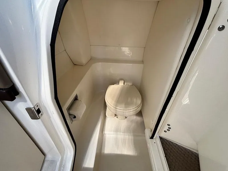 Slide: The Image of 2013 Sea Ray 250 SLX boat interior with compact marine toilet. - 21