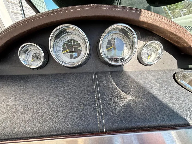 Slide: The Image of Dashboard of 2013 Sea Ray 250 SLX boat with chrome-rimmed gauges. - 24