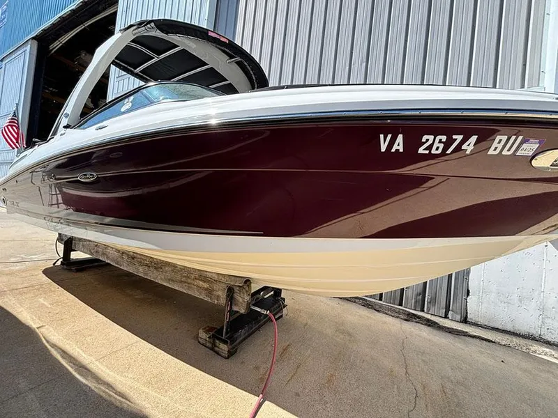 Slide: The Image of 2013 Sea Ray 250 SLX boat on a lift, maroon and white exterior. - 3