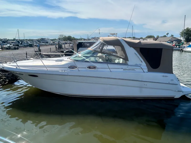 Slide: The Image of 2000 Sea Ray 290 Sundancer boat docked in a marina under a clear sky. - 1