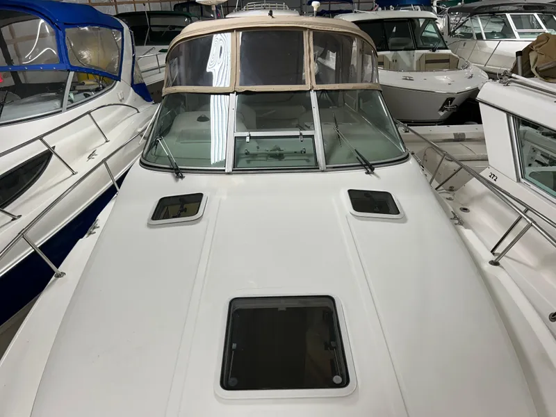 Slide: The Image of 2000 Sea Ray 290 Sundancer boat in storage, surrounded by other vessels. - 10