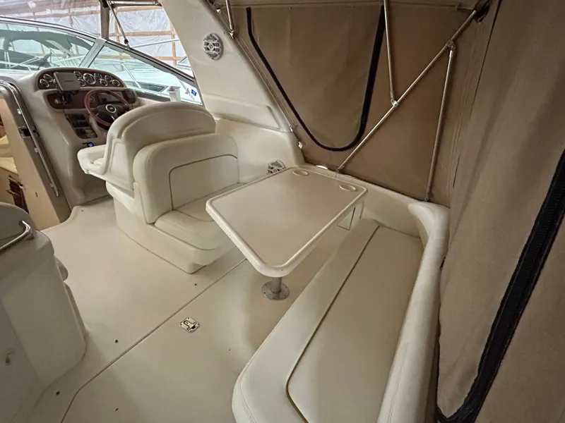 Slide: The Image of 2000 Sea Ray 290 Sundancer interior with seating and table, showcasing luxury boat design. - 13