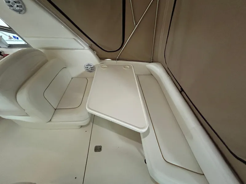 Slide: The Image of Interior seating area of 2000 Sea Ray 290 Sundancer boat with table. - 14