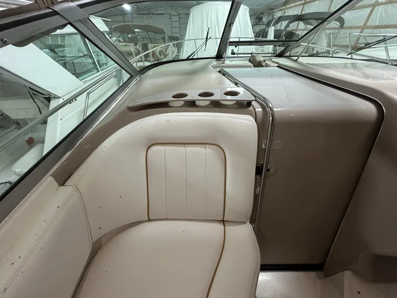 Slide: The Image of 2000 Sea Ray 290 Sundancer interior with beige seating and cup holders. - 18