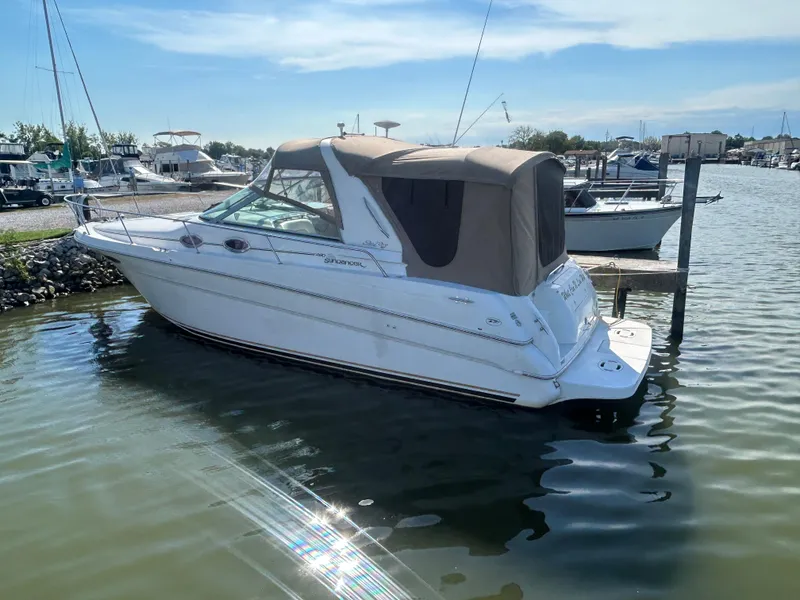 Slide: The Image of 2000 Sea Ray 290 Sundancer boat docked in a marina under clear skies. - 2