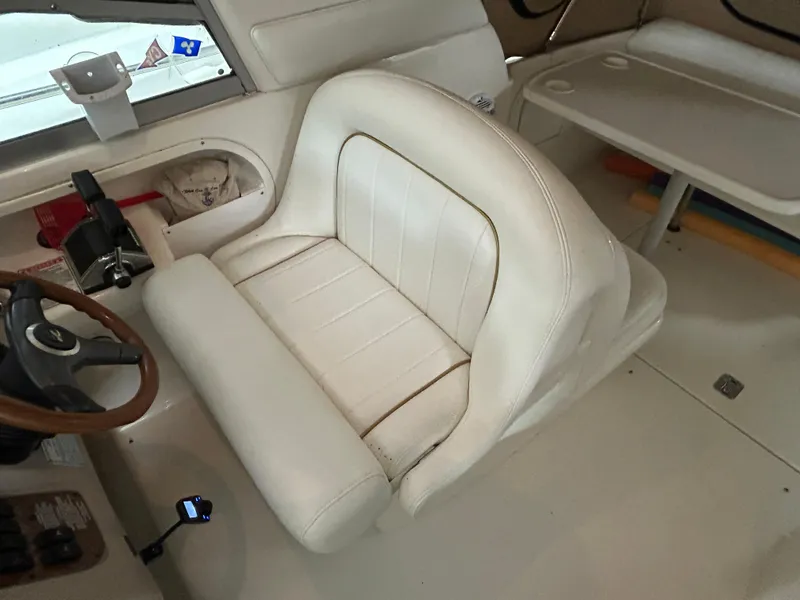 Slide: The Image of Interior of 2000 Sea Ray 290 Sundancer with white leather seating and steering wheel. - 21