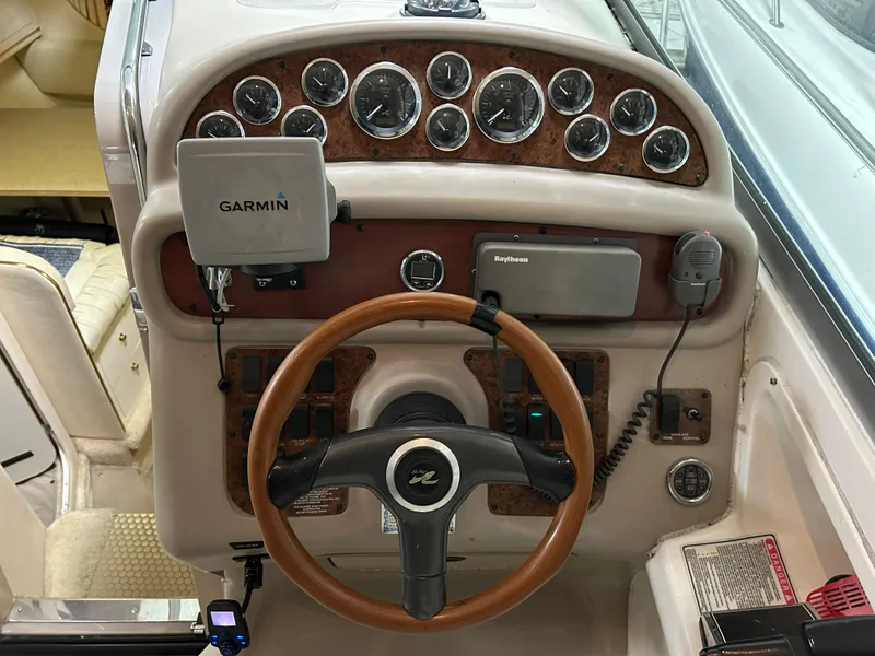 Slide: The Image of 2000 Sea Ray 290 Sundancer dashboard with Garmin and Raytheon navigation systems. - 22