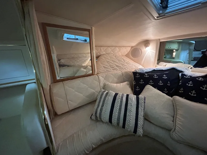 Slide: The Image of Cozy interior cabin of 2000 Sea Ray 290 Sundancer with nautical-themed pillows. - 29