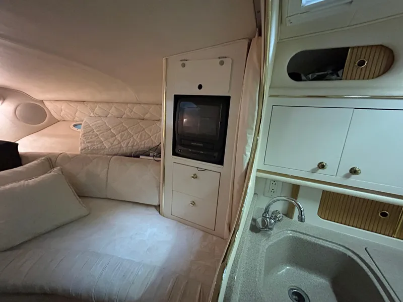 Slide: The Image of Interior of 2000 Sea Ray 290 Sundancer with TV, sofa, and kitchenette. - 30