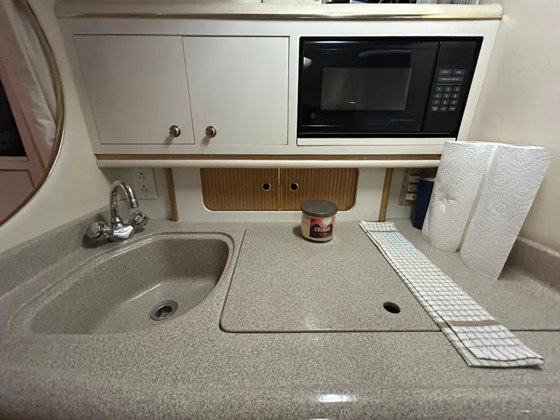 Slide: The Image of Compact kitchen area in a 2000 Sea Ray 290 Sundancer boat with sink and microwave. - 32
