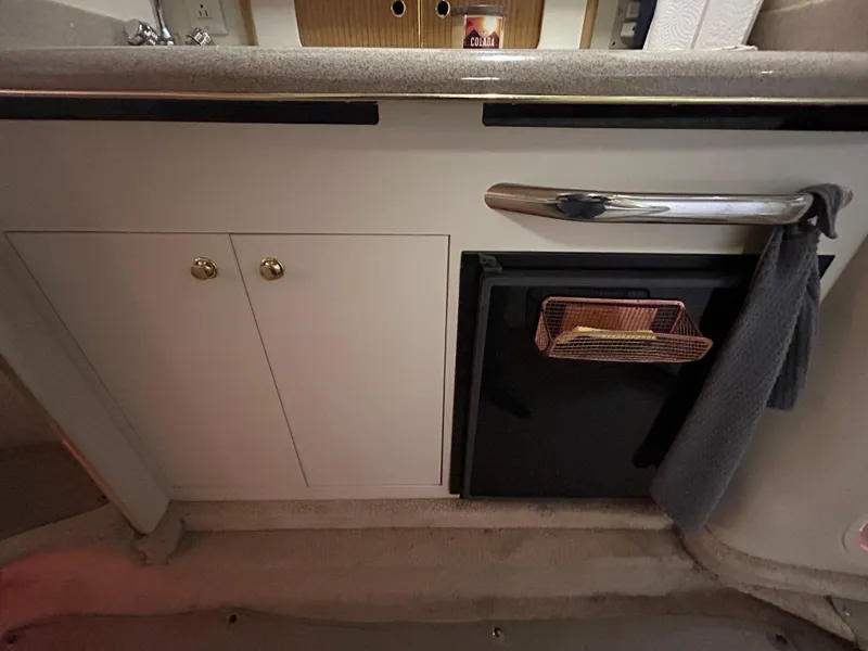Slide: The Image of 2000 Sea Ray 290 Sundancer interior kitchen with cabinets and mini fridge. - 33