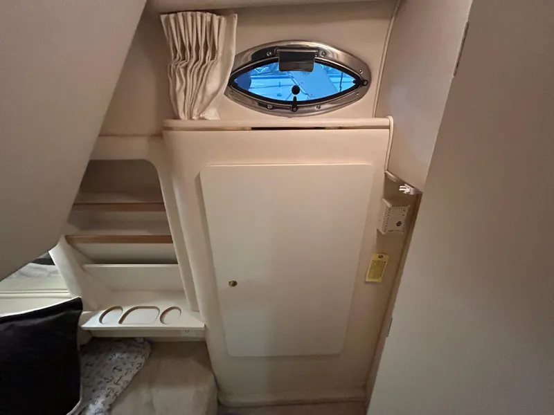 Slide: The Image of Interior cabin of 2000 Sea Ray 290 Sundancer with storage and porthole window. - 38