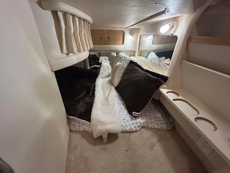 Slide: The Image of Cozy cabin interior of 2000 Sea Ray 290 Sundancer with plush bedding and soft lighting. - 40