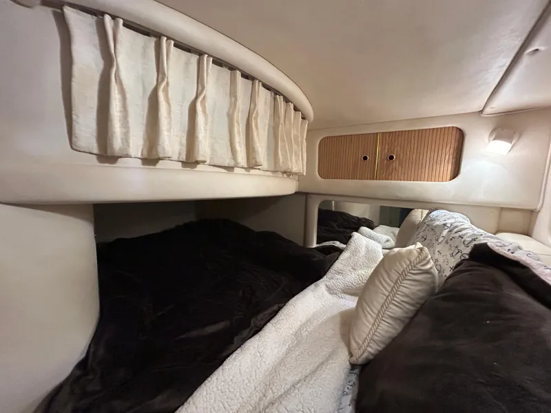 Slide: The Image of Interior cabin of 2000 Sea Ray 290 Sundancer with cozy bedding and curtains. - 41