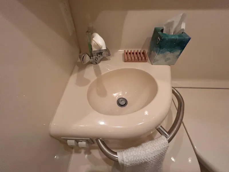 Slide: The Image of Compact bathroom sink in 2000 Sea Ray 290 Sundancer boat, with towel and tissue box. - 44