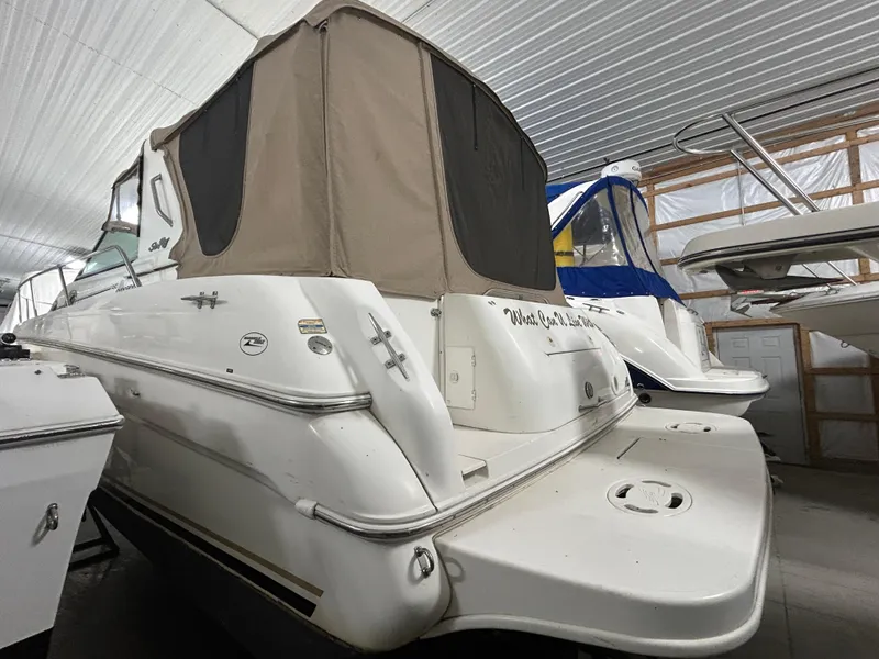 Slide: The Image of 2000 Sea Ray 290 Sundancer boat in storage, featuring a covered cockpit area. - 6
