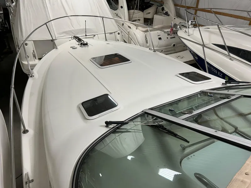 Slide: The Image of 2000 Sea Ray 290 Sundancer boat in storage, showcasing sleek design and spacious deck. - 8