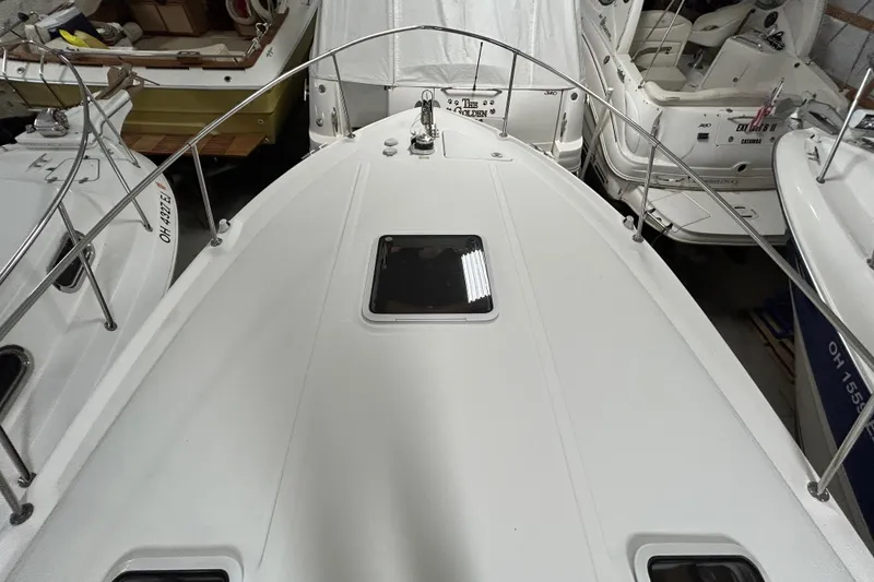 Slide: The Image of 2000 Sea Ray 290 Sundancer boat deck with railing and hatch, docked indoors. - 9