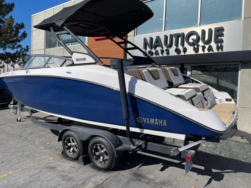 Slide: The Image of 2021 Yamaha Boats 252SE in blue, parked outside Nautique Boats of Utah. - 1