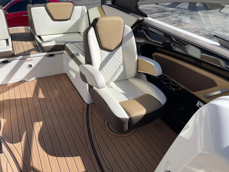 Slide: The Image of 2021 Yamaha Boats 252SE interior with luxurious seating and wood-style flooring. - 11