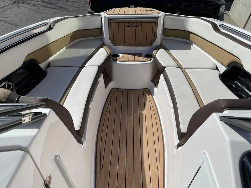 Slide: The Image of 2021 Yamaha Boats 252SE interior with cushioned seating and wood finish. - 12
