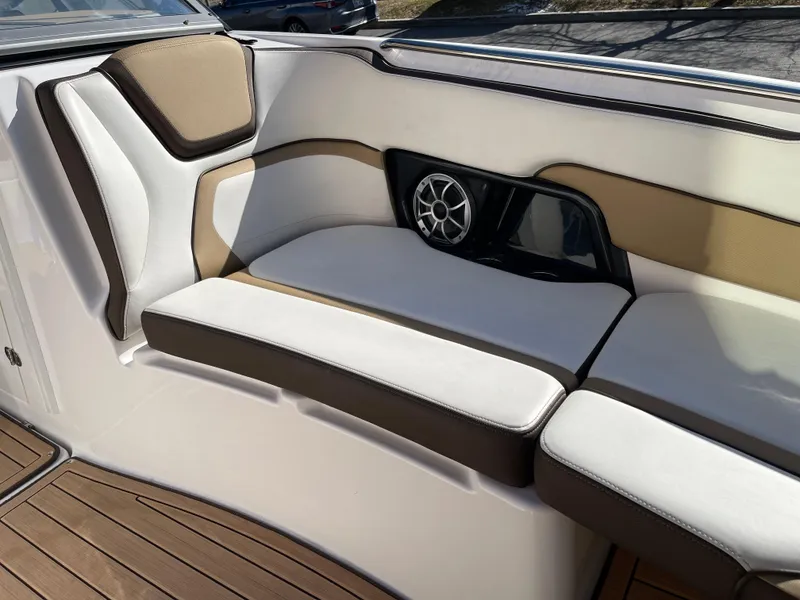 Slide: The Image of 2021 Yamaha Boats 252SE interior seating with speaker, featuring white and tan upholstery. - 13