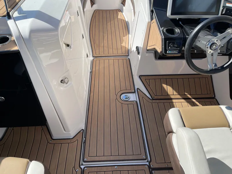Slide: The Image of 2021 Yamaha Boats 252SE interior with sleek wood flooring and modern steering console. - 8