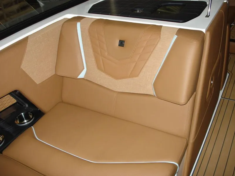 Slide: The Image of 2024 Nautique Super Air Nautique G23 interior with tan leather seating and cup holders. - 14