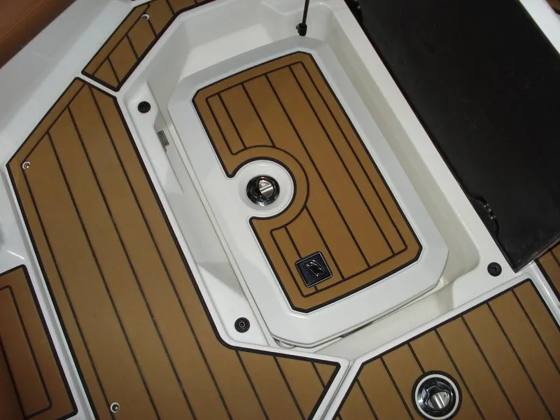 Slide: The Image of 2024 Nautique Super Air Nautique G23 deck with teak-style flooring and storage compartment. - 23