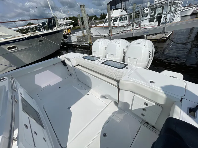 Slide: The Image of 2022 Bertram 39 CC boat with triple outboard engines docked at marina. - 12