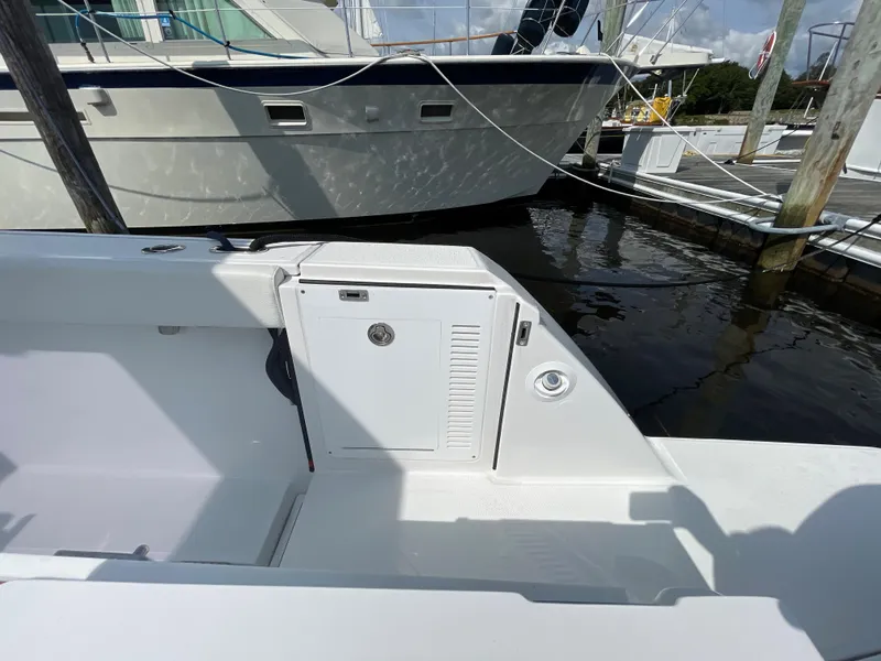 Slide: The Image of 2022 Bertram 39 CC boat interior, featuring sleek white design and storage compartment. - 20