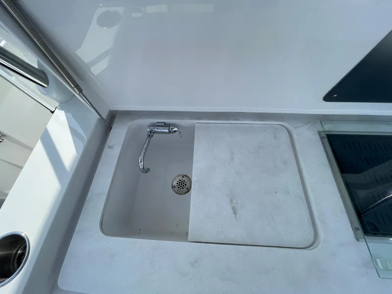 Slide: The Image of 2022 Bertram 39 CC boat sink with faucet in white countertop. - 27