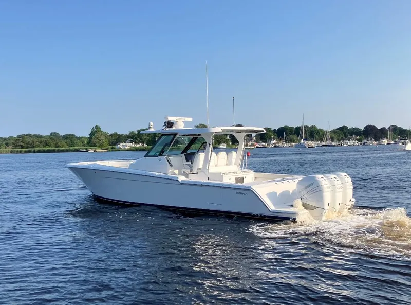 Slide: The Image of 2022 Bertram 39 CC boat cruising on a calm lake with clear skies. - 3