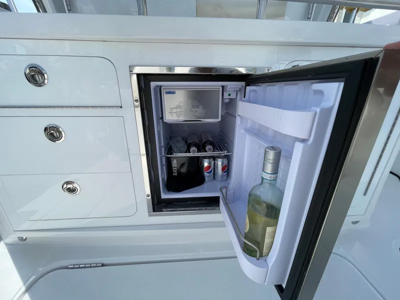 Slide: The Image of Open mini fridge on 2022 Bertram 39 CC boat, stocked with drinks. - 31